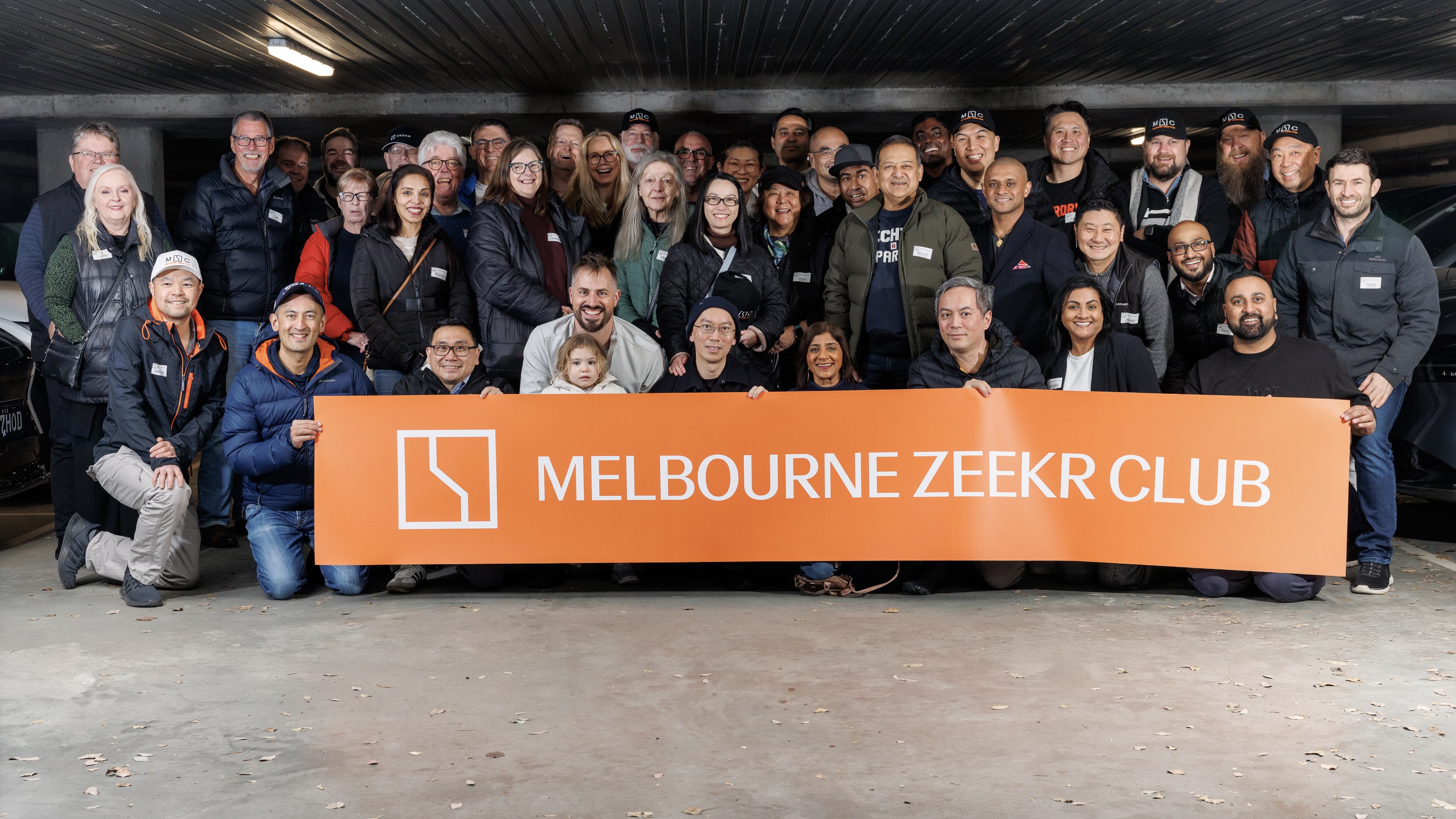 Melbourne ZEEKR Club members and guests gathered behind the orange club banner at the Notting Hill Hotel dinner.